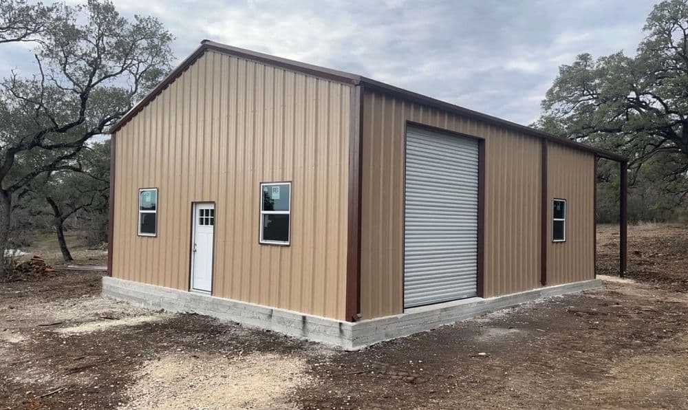 Metal storage building with roll-up door and white entry door, set in a rural landscape.